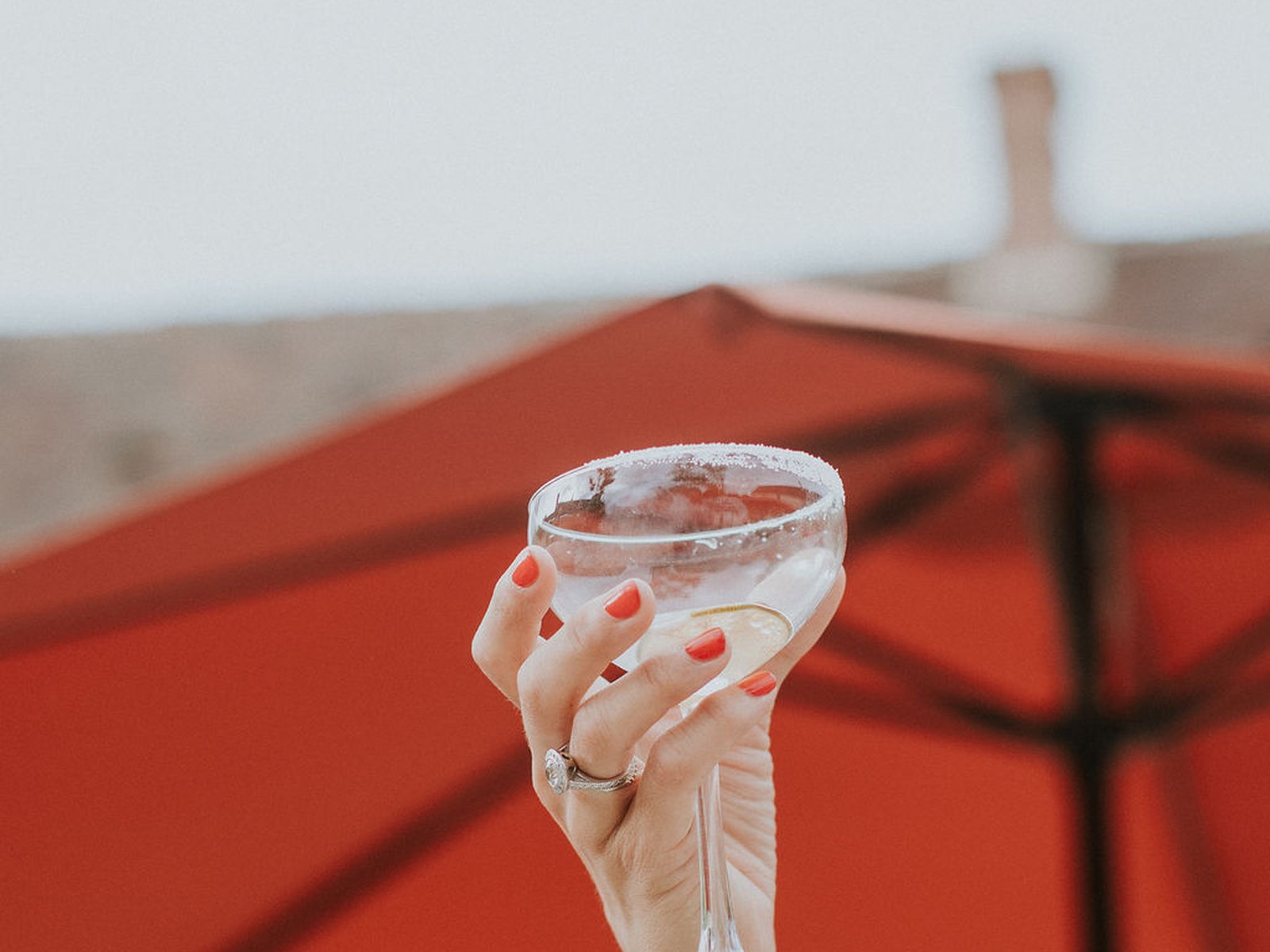 A coupe raised beneath the cocktail parasols