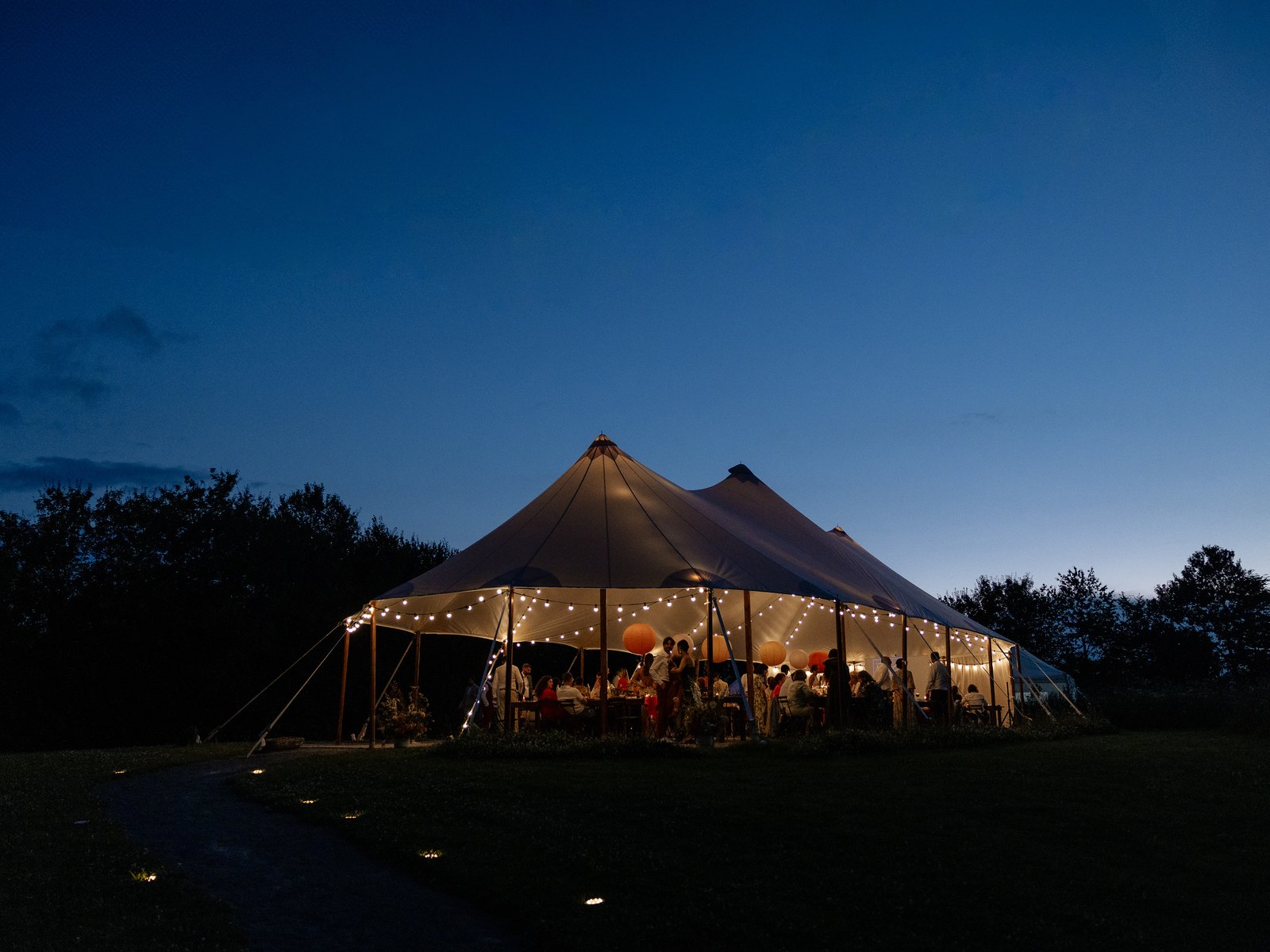 The marquee glowing at blue hour in the grounds